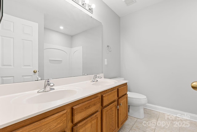 bathroom featuring toilet, vanity, and tile patterned flooring