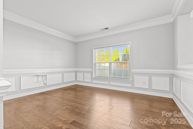 spare room featuring ornamental molding and hardwood / wood-style floors