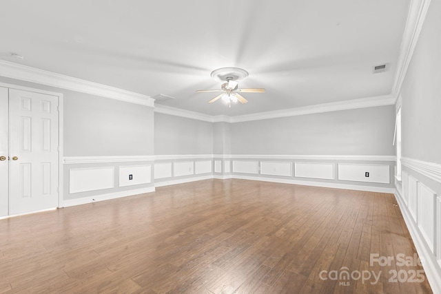 spare room featuring ceiling fan, wood-type flooring, and crown molding