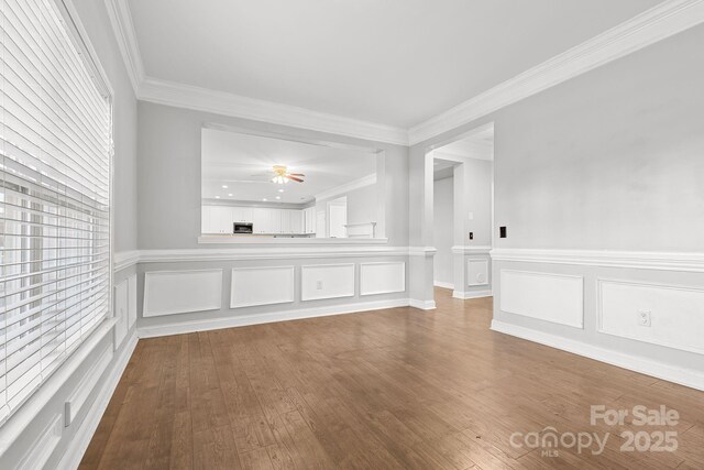 unfurnished room featuring hardwood / wood-style flooring, crown molding, and ceiling fan