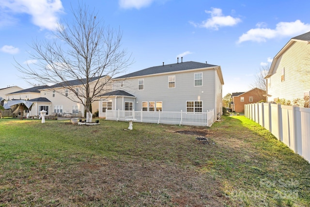 rear view of property featuring a lawn