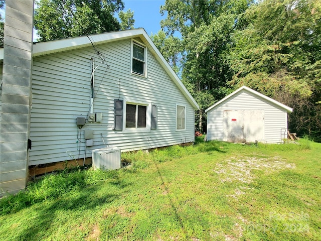 exterior space with a shed, a yard, and central air condition unit