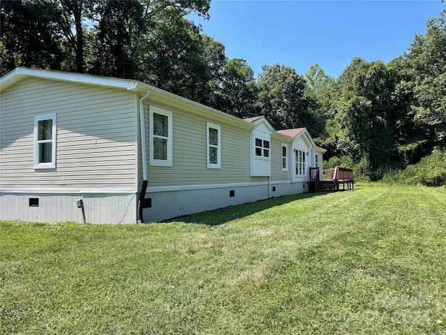 view of home's exterior with crawl space, a lawn, and a deck