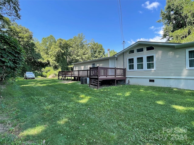 exterior space featuring crawl space, central air condition unit, a wooden deck, and a yard