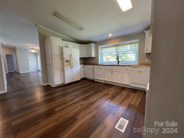 kitchen featuring white appliances, dark wood-style floors, visible vents, a sink, and vaulted ceiling