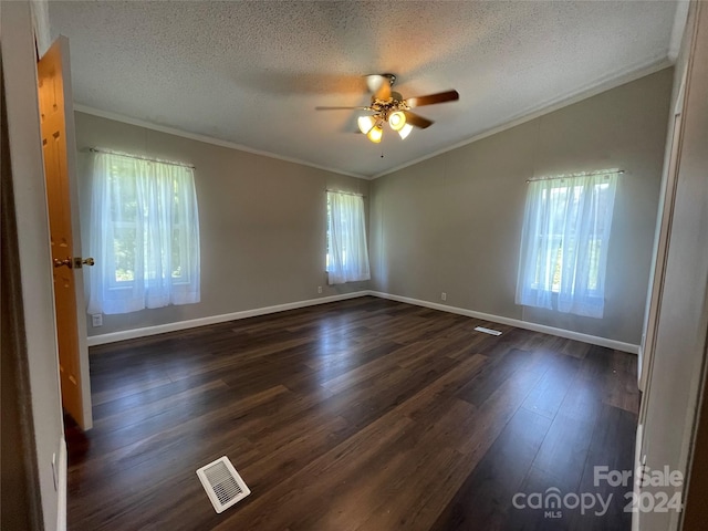 spare room featuring dark wood finished floors, plenty of natural light, lofted ceiling, and ornamental molding