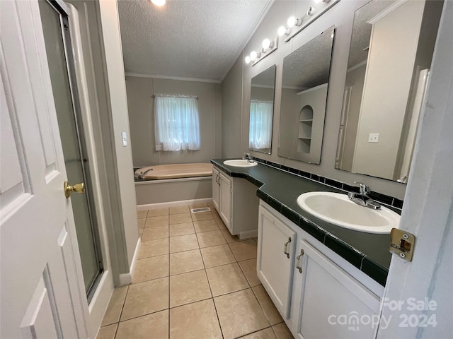 full bathroom featuring double vanity, ornamental molding, a sink, a textured ceiling, and tile patterned floors