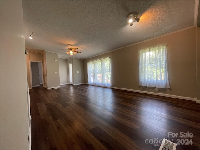 unfurnished living room with baseboards, a textured ceiling, dark wood finished floors, and ornamental molding