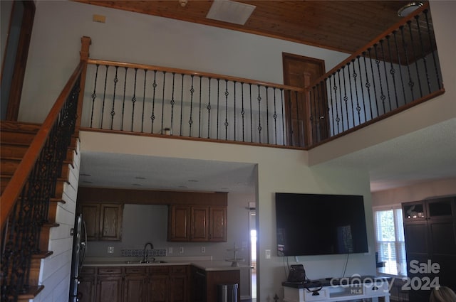 interior space with sink, refrigerator, and a high ceiling