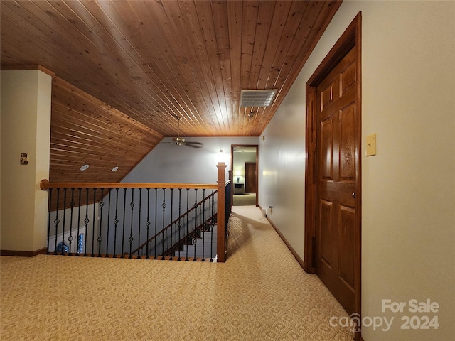 corridor featuring light colored carpet, vaulted ceiling, and wooden ceiling