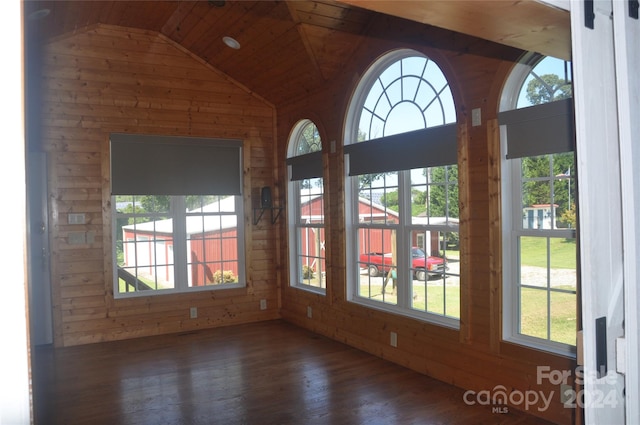 interior space featuring dark hardwood / wood-style floors, wooden ceiling, wooden walls, and vaulted ceiling