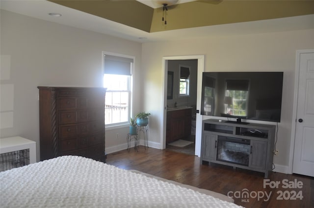 bedroom with connected bathroom, dark hardwood / wood-style floors, and ceiling fan