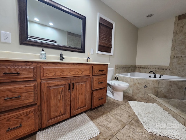 bathroom with tiled bath, tile patterned flooring, vanity, and toilet