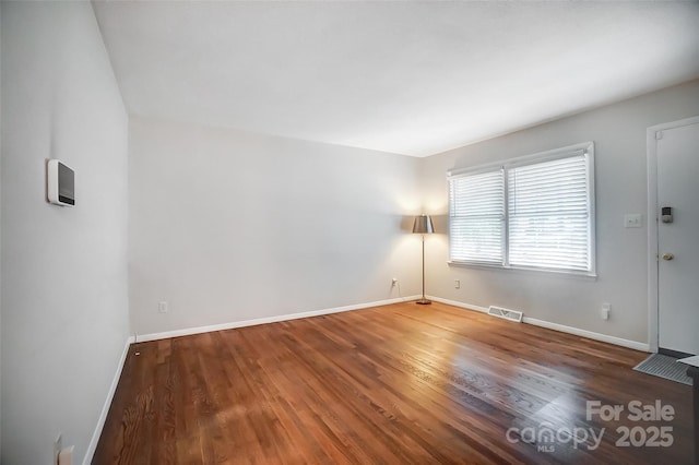 spare room with dark wood-type flooring