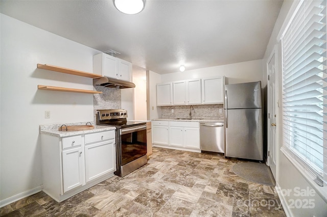 kitchen with appliances with stainless steel finishes, white cabinets, tasteful backsplash, and sink