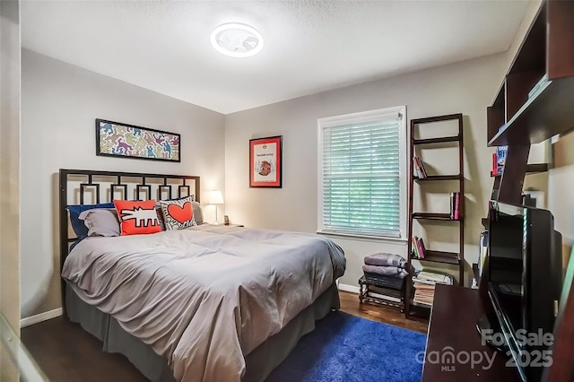 bedroom with dark wood-type flooring