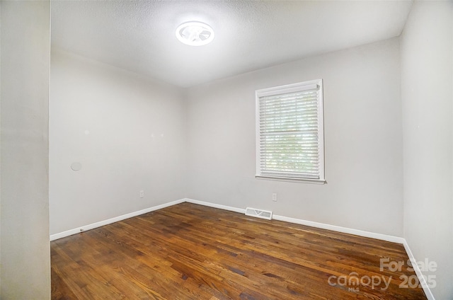 spare room with dark hardwood / wood-style flooring