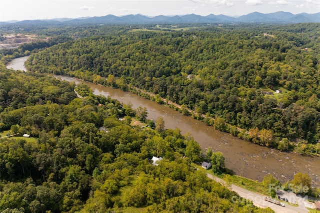 drone / aerial view featuring a forest view and a water and mountain view