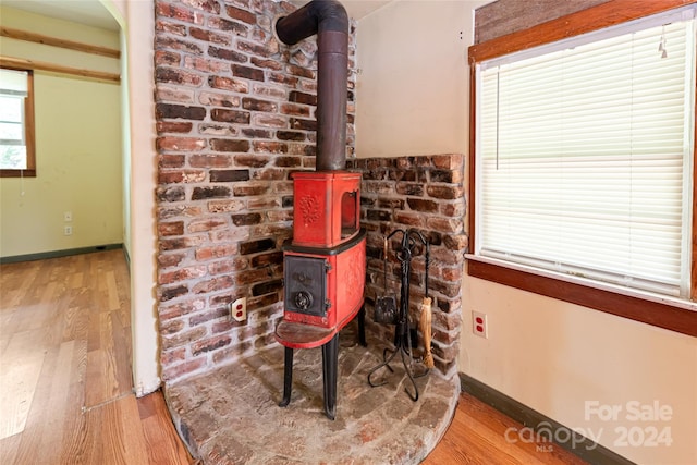 room details with baseboards, a wood stove, and wood finished floors