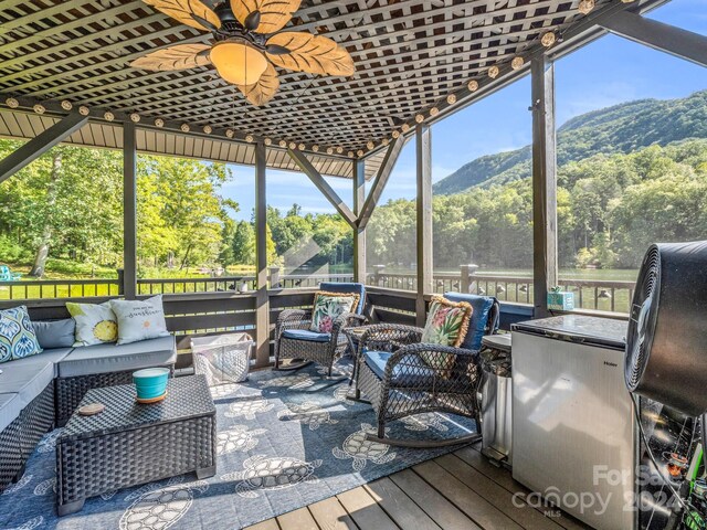 sunroom featuring a mountain view and ceiling fan