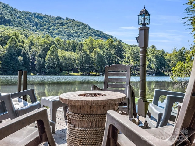 dock area with a fire pit and a water view