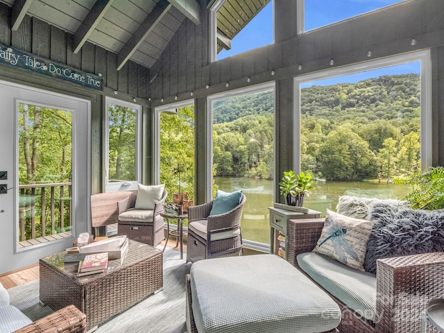 sunroom with lofted ceiling with beams, a water view, a healthy amount of sunlight, and wood ceiling