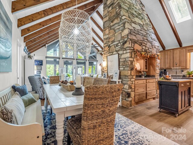 dining area featuring light wood-type flooring, beamed ceiling, and high vaulted ceiling