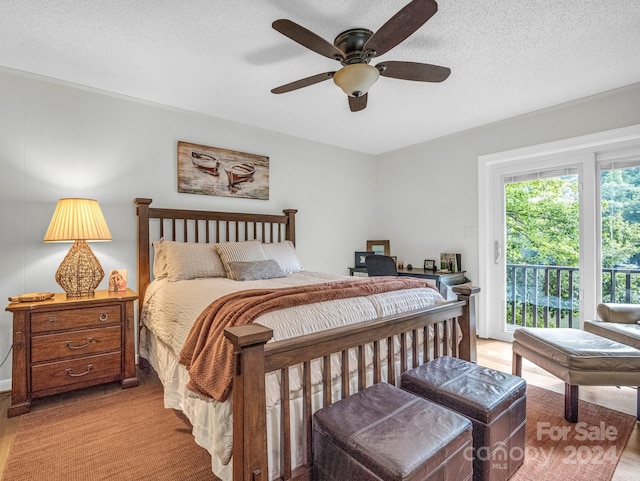 bedroom with a textured ceiling, light hardwood / wood-style flooring, ceiling fan, and access to outside