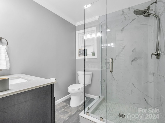 bathroom with vanity, toilet, ornamental molding, and a shower with shower door