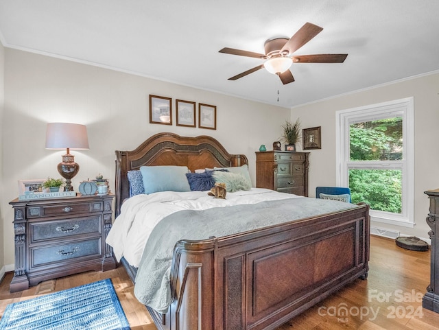 bedroom featuring ceiling fan, ornamental molding, and hardwood / wood-style flooring