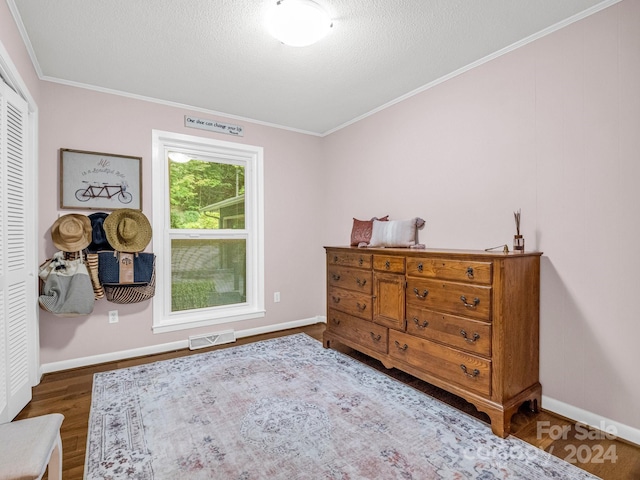 bedroom with a closet, hardwood / wood-style flooring, and crown molding