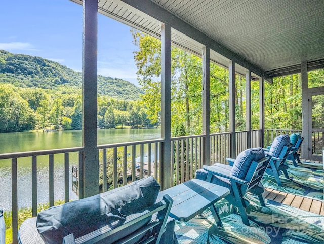 sunroom featuring a water view