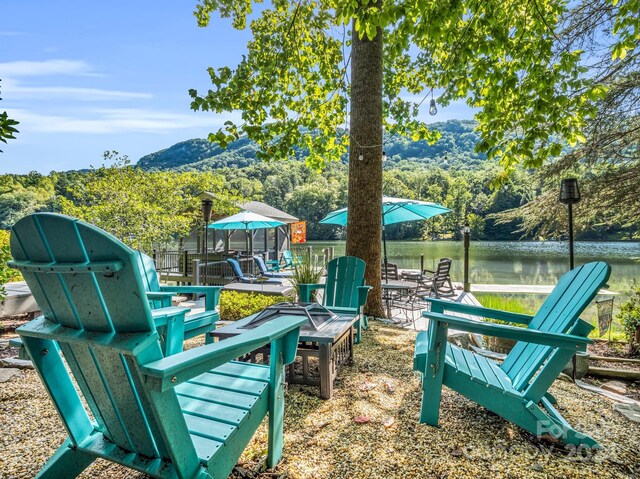 view of yard featuring an outdoor fire pit and a water view