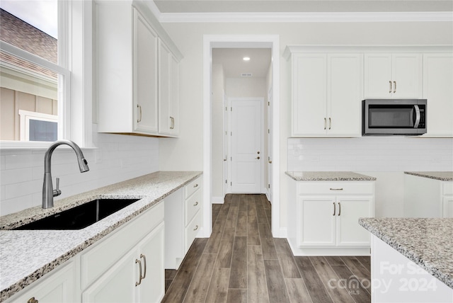 kitchen featuring sink, white cabinetry, hardwood / wood-style flooring, and tasteful backsplash