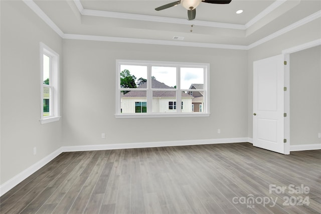 spare room with hardwood / wood-style floors, crown molding, ceiling fan, and a tray ceiling