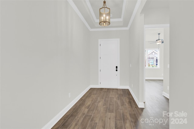 entrance foyer featuring ceiling fan with notable chandelier, hardwood / wood-style flooring, crown molding, and a tray ceiling