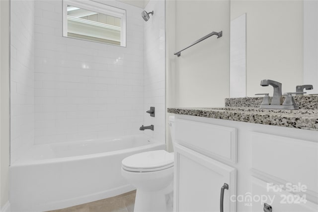 full bathroom featuring tile patterned flooring, toilet, tiled shower / bath, and vanity