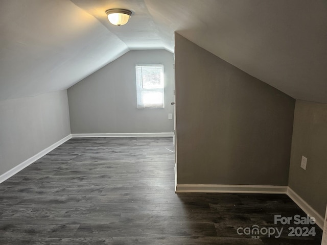 bonus room featuring dark wood-style floors, lofted ceiling, and baseboards