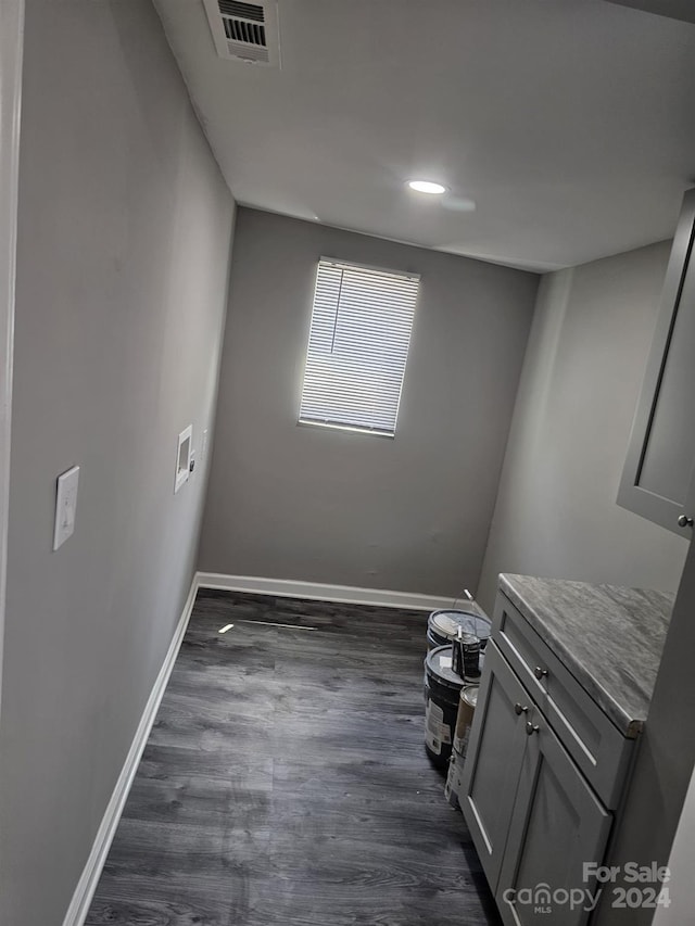 interior space featuring dark wood-style flooring, visible vents, and baseboards