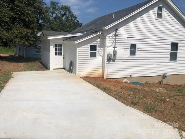 back of house with roof with shingles