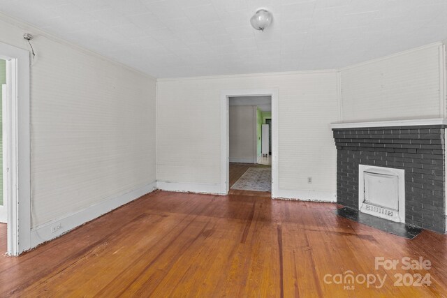 unfurnished living room with hardwood / wood-style flooring and a fireplace