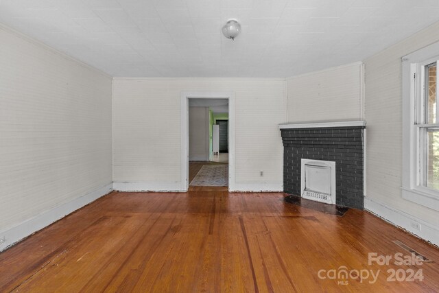 unfurnished living room featuring a fireplace and hardwood / wood-style floors