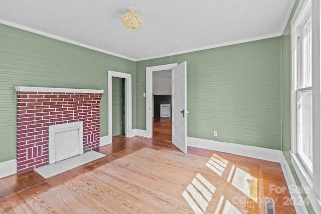 unfurnished living room featuring hardwood / wood-style floors and ornamental molding