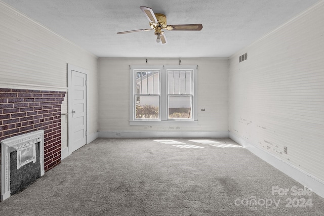 unfurnished living room with ceiling fan, carpet flooring, crown molding, and a fireplace