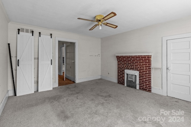 unfurnished living room featuring a fireplace, ceiling fan, crown molding, and carpet