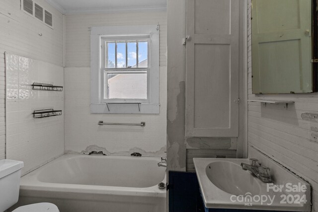 bathroom featuring a bath, crown molding, toilet, and vanity