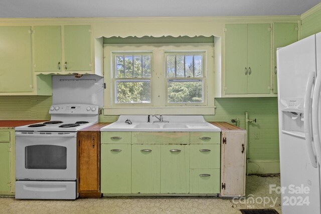 kitchen featuring sink, white appliances, and green cabinets