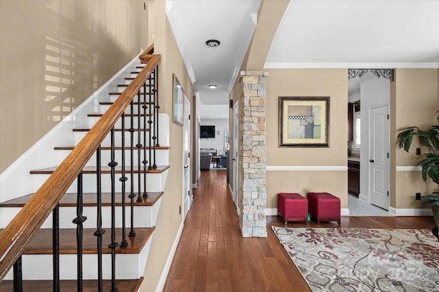 stairway featuring crown molding and hardwood / wood-style floors