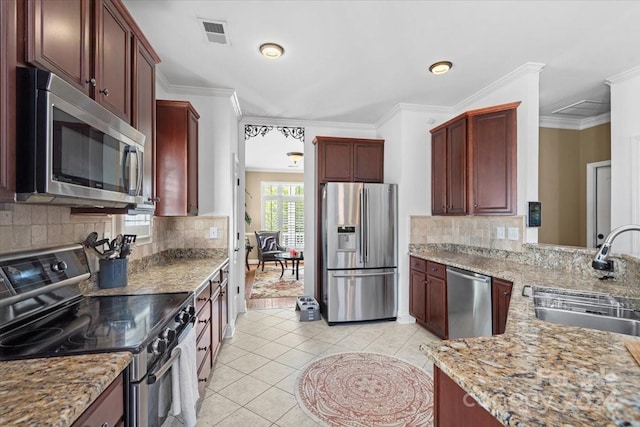 kitchen with light tile patterned floors, tasteful backsplash, stainless steel appliances, ornamental molding, and sink