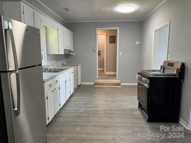 kitchen with stainless steel appliances, a sink, light wood-style floors, white cabinets, and light countertops